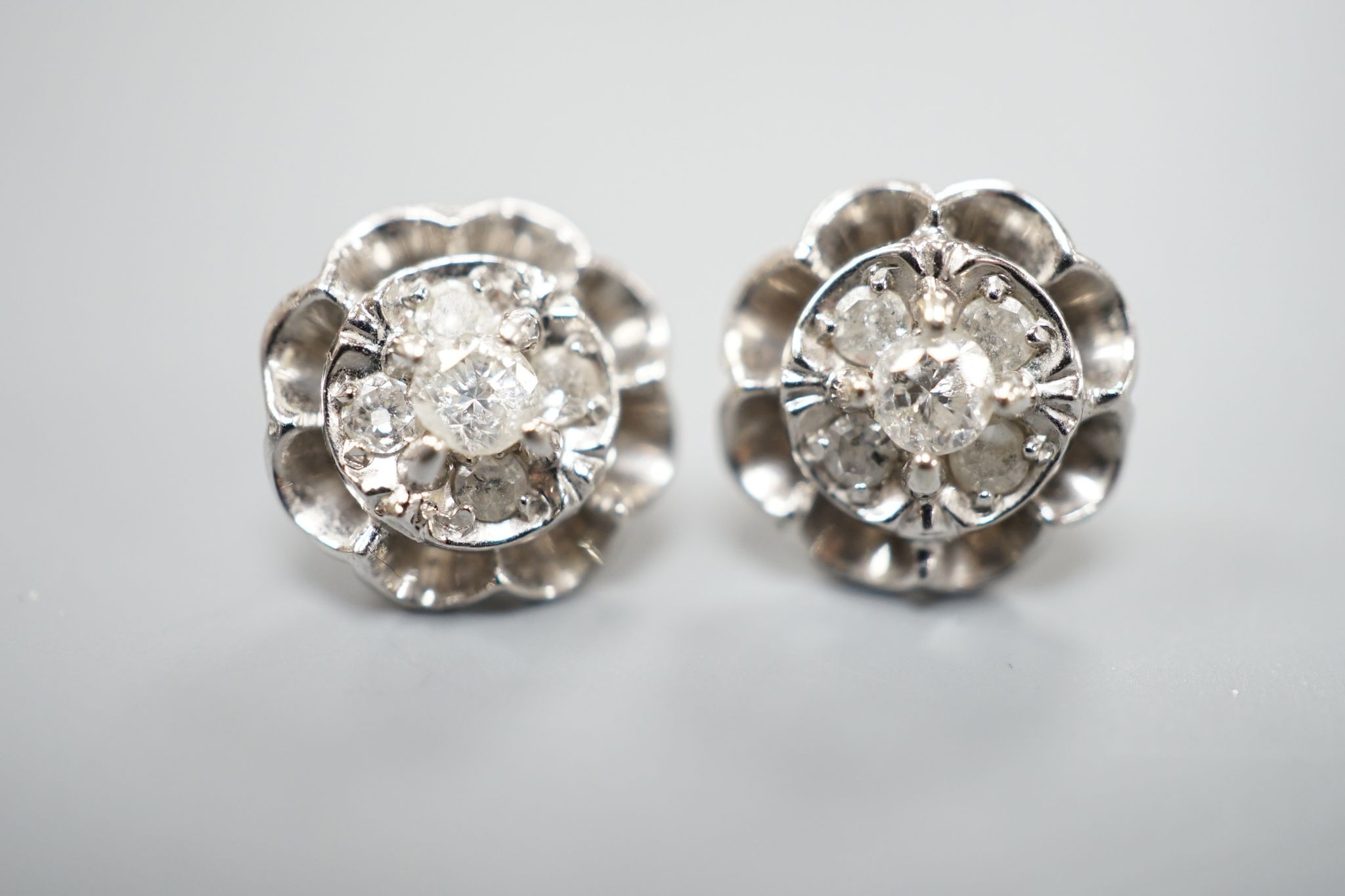 A pair of 750 white metal and five stone diamond cluster set earrings, 10mm, gross weight 3.2 grams.